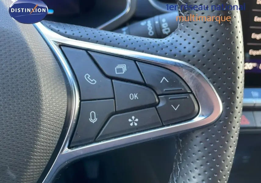 Gros plan sur les commandes multifonctions du volant en cuir perforé noir d'une Renault Symbioz bleu iron metal.