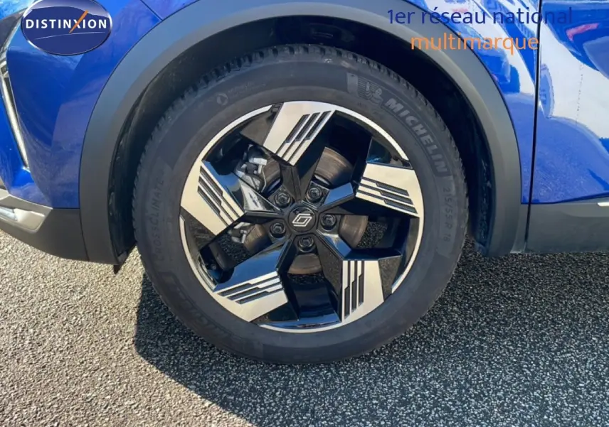 Gros plan sur la roue avant droite bleu iron metal du Renault Symbioz 2025 avec jante noire et argentée design moderne.