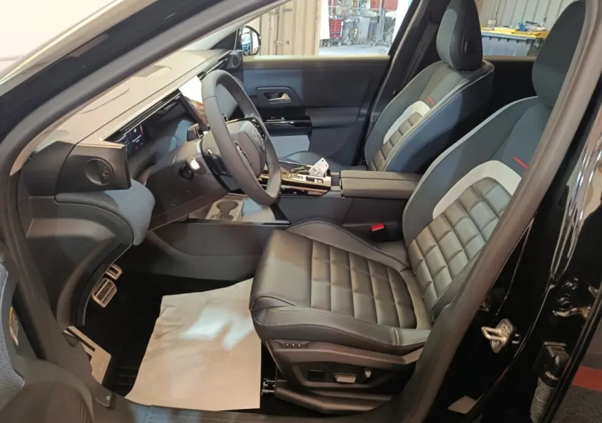 Intérieur avant droit du Citroën C5 Hybride noir 2026, sièges cuir noir et tableau de bord moderne avec écran tactile.