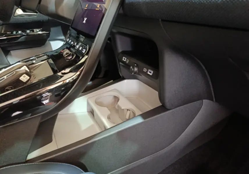 Intérieur noir du Citroën C5 Hybride 2026, vue sur console centrale avec écran tactile et porte-gobelets.