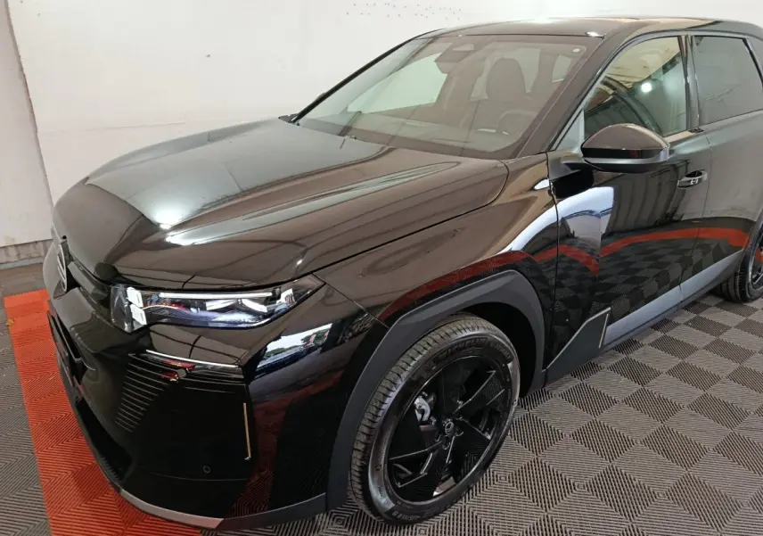 Vue 3/4 avant droite d'une Citroën C5 Hybride noire, avec phares LED et jantes noires distinctives.