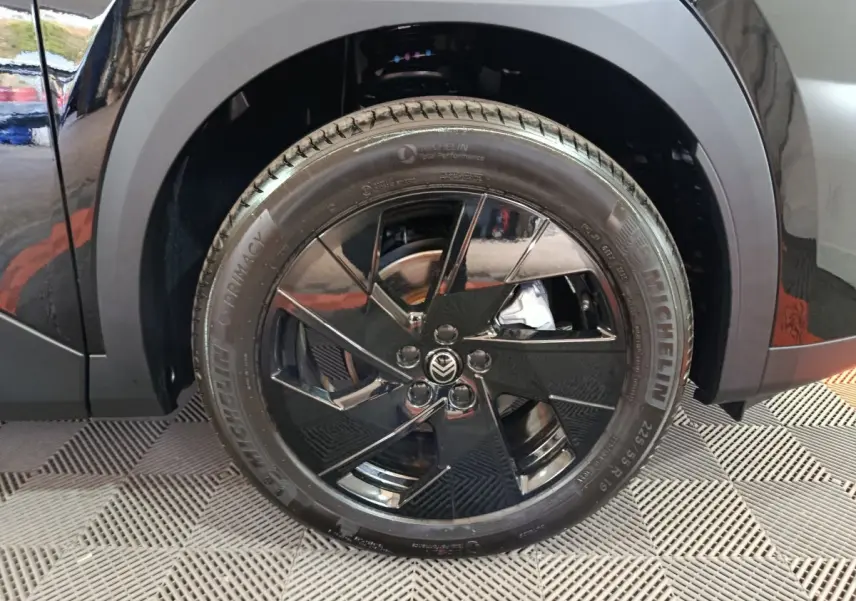 Gros plan sur la roue avant gauche noire avec jante en alliage noir brillant du Citroën C5 Hybride 2026.