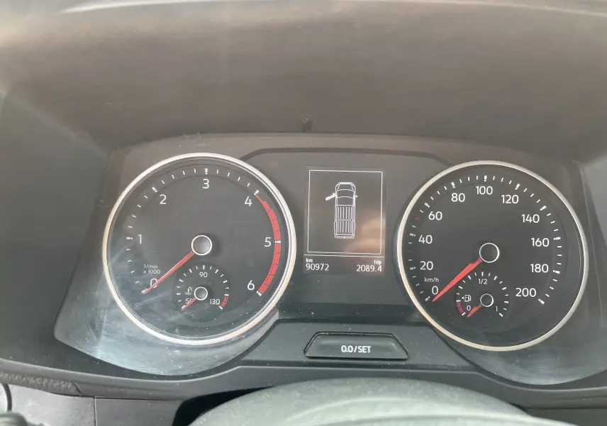 Tableau de bord du Volkswagen Crafter blanc 2019 montrant compte-tours, vitesse et écran central avec porte ouverte à gauche.