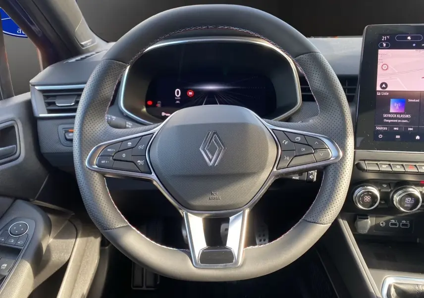 Vue centrée sur le volant perforé noir de la Renault Clio V TCE 90 Esprit Alpine avec tableau de bord numérique et écran tactile.