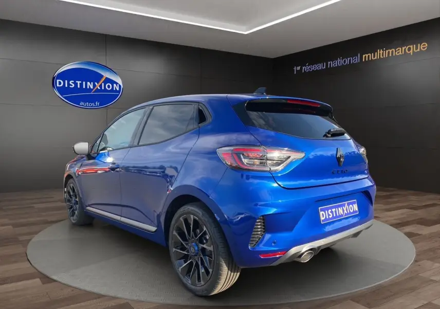 Vue 3/4 arrière droite d'une Renault Clio V TCE 90 Esprit Alpine bleu Iron avec jantes noires et échappement chromé.