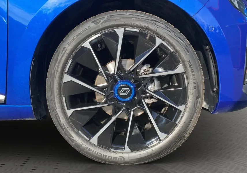 Gros plan sur la roue avant droite de la Renault Clio V TCE 90 Esprit Alpine bleu Iron avec jante noire et argentée.