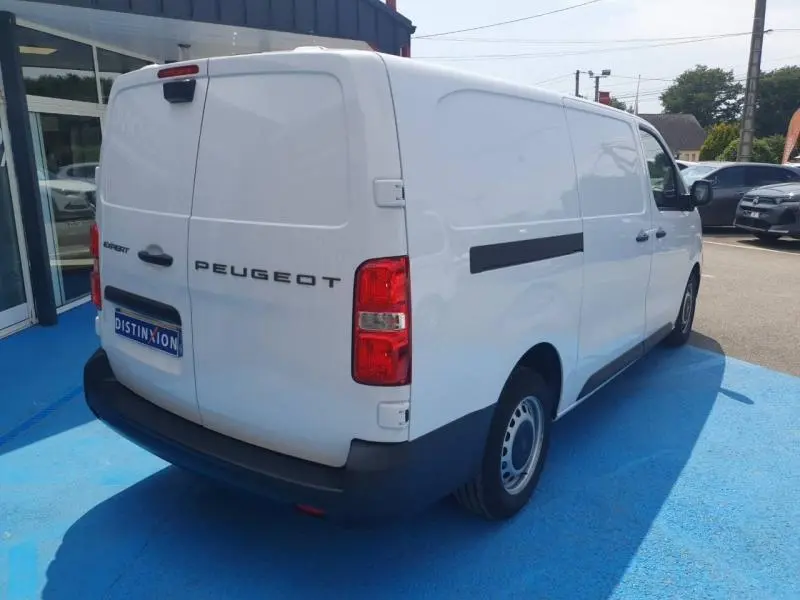 Vue 3/4 arrière droite d'un Peugeot Expert Fourgon blanc avec porte latérale coulissante et double portes arrière fermées.