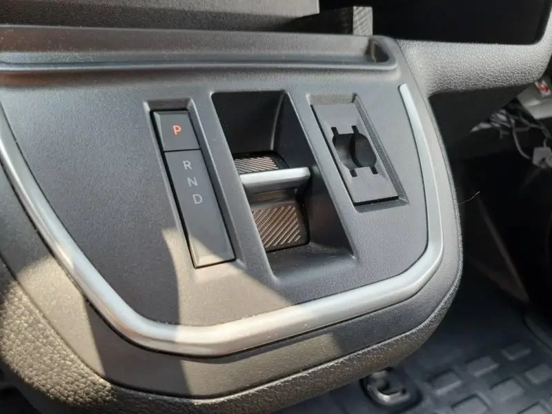 Gros plan sur la console centrale du Peugeot Expert Fourgon blanc, montrant la commande de boîte automatique et un rangement.