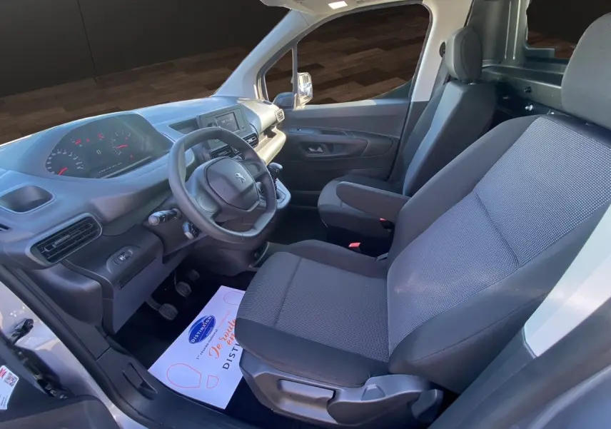 Vue intérieure côté conducteur du Peugeot Partner Fourgon Dangel 4x4 2025, sièges tissu noir et tableau de bord moderne.