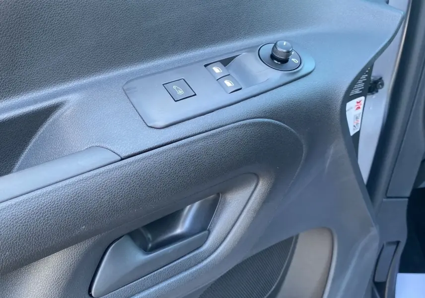Gros plan sur la porte intérieure côté gauche du Peugeot Partner Fourgon Dangel 4x4 gris Artense, avec commandes électriques.