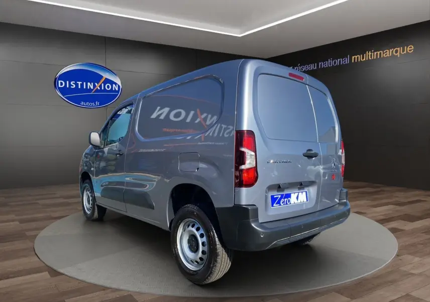 Peugeot Partner Fourgon gris Artense métal vu en 3/4 arrière droit avec portes arrière fermées dans un showroom.