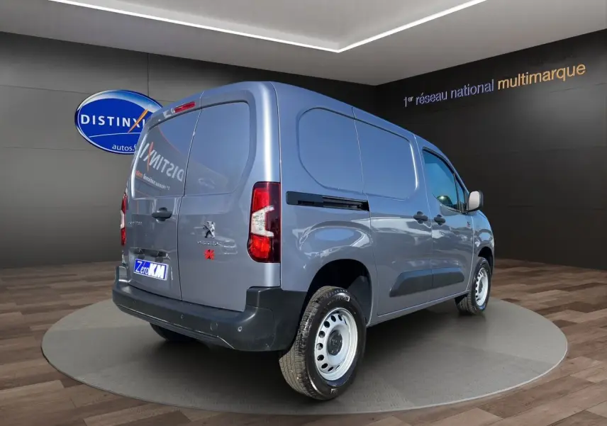 Vue 3/4 arrière droite du Peugeot Partner Fourgon Dangel 4x4 gris Artense métallisé en showroom.