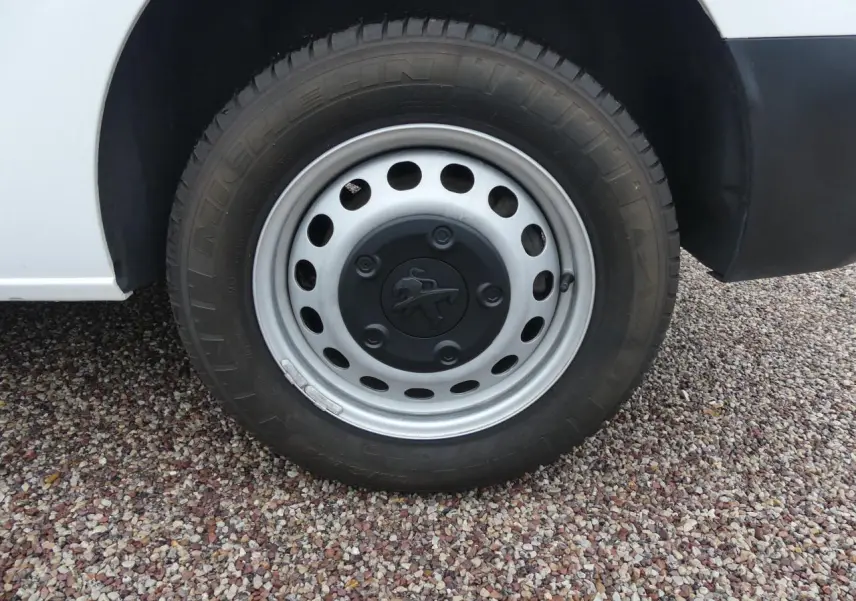 Gros plan sur la roue avant droite du Peugeot Expert Fourgon blanc, avec jante acier et logo Peugeot central.