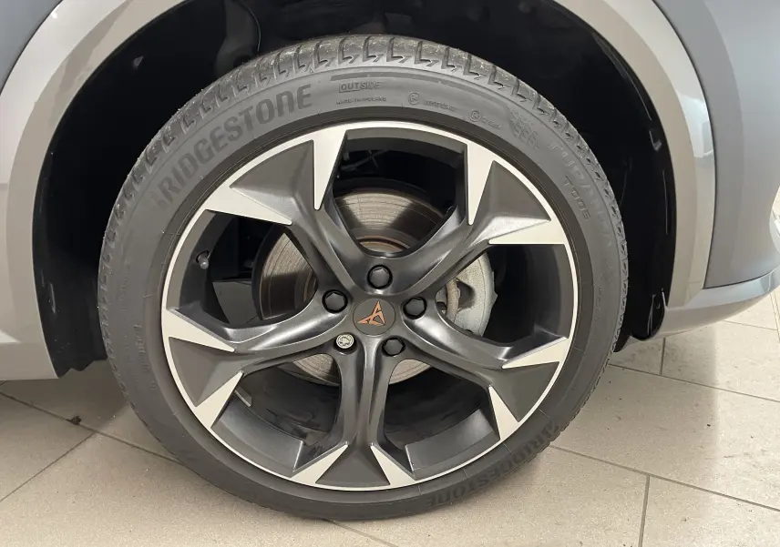 Gros plan sur la jante alliage gris foncé et argentée avec logo CUPRA sur le côté avant droit du Formentor gris magnétique mat.