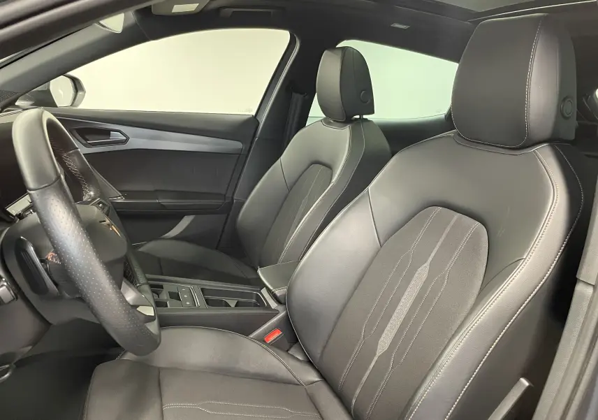 Vue intérieure côté conducteur du CUPRA Formentor 1.5 TSI 150 DSG7 avec sièges cuir noir et surpiqûres contrastées.