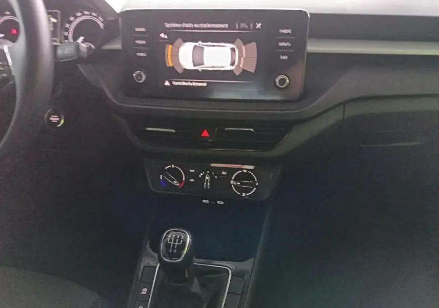 Vue intérieure centrée sur la console centrale de la Skoda Fabia 2022, avec écran tactile et levier de vitesse manuel.