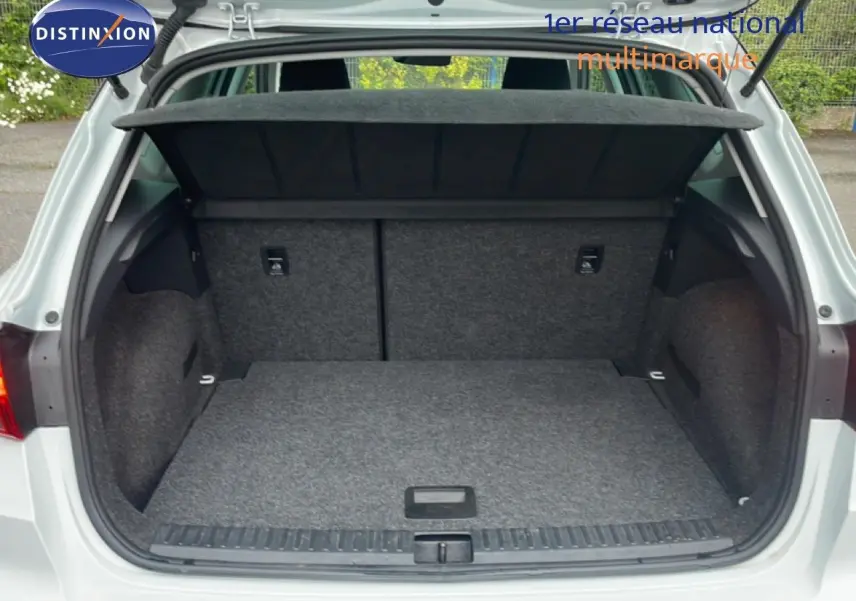Coffre ouvert vu de l'arrière d'un SEAT Arona blanc alpin métal avec toit noir, montrant un espace de chargement vide et propre.