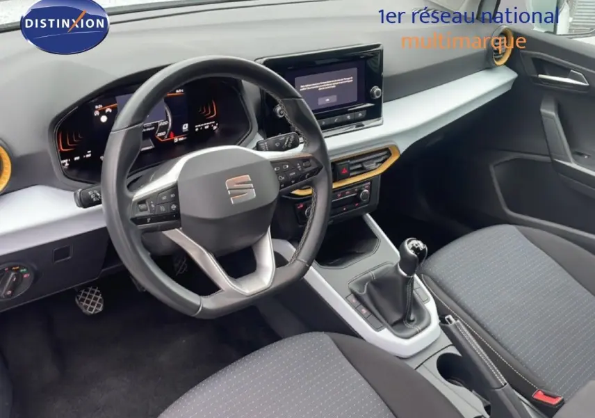 Vue intérieure côté conducteur du tableau de bord et volant cuir noir de la SEAT Arona 2025, avec levier de vitesses manuel.