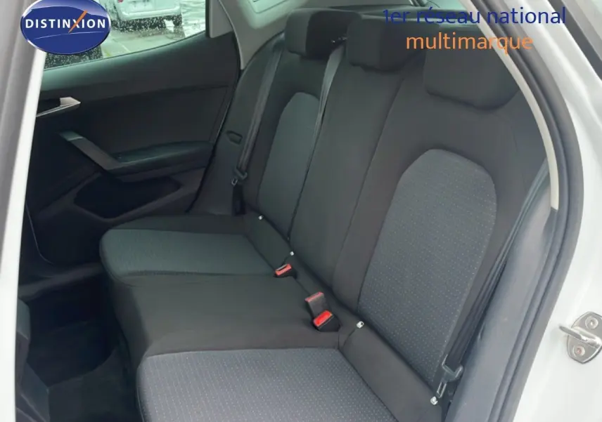 Vue intérieure côté droit montrant la banquette arrière en tissu noir du SEAT Arona blanc alpin 2025.