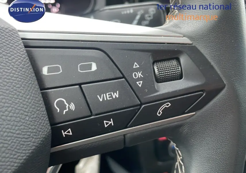 Gros plan sur les commandes au volant du SEAT Arona 2025, boutons noirs avec fonctions vocales et appel téléphonique.