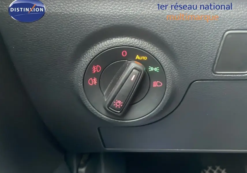Gros plan sur le bouton de commande des phares dans l’habitacle noir du SEAT Arona blanc au toit noir.