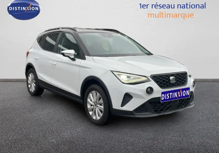 SEAT Arona blanc alpin métal avec toit noir, vue 3/4 avant mettant en valeur ses phares LED et calandre noire.
