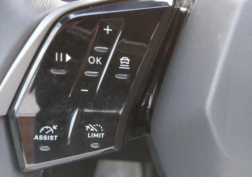 Gros plan sur les commandes au volant noir du Peugeot 3008 Hybrid 136 e-DCS6 Allure, avec boutons de régulateur et limiteur.
