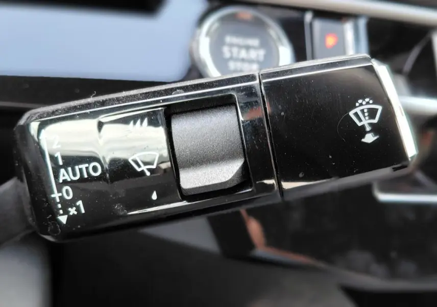 Gros plan sur la commande des essuie-glaces du Peugeot 3008 Hybrid 136 e-DCS6 Allure, intérieur noir brillant.