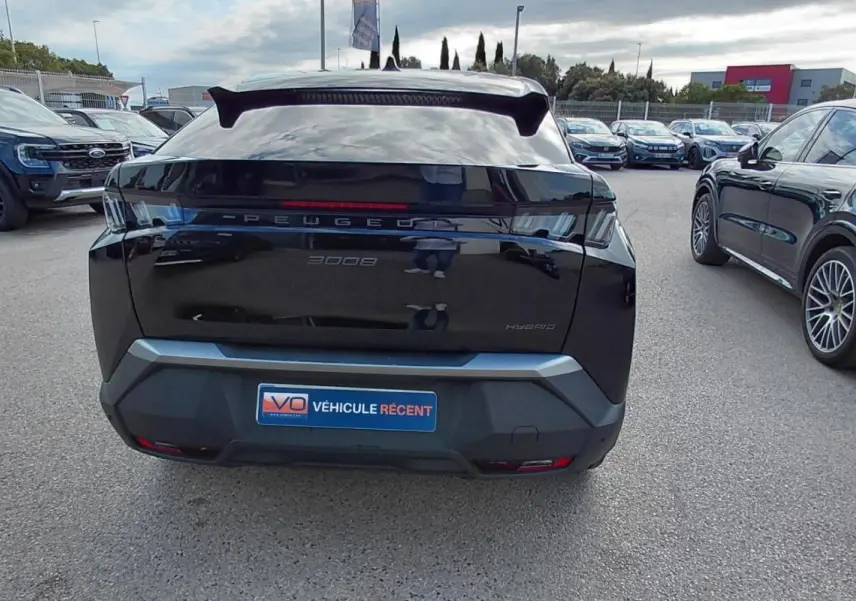 Vue arrière d’un Peugeot 3008 Hybrid noir 2025 avec jantes alliage 19 pouces sur parking extérieur.