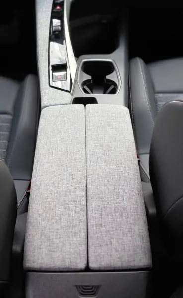 Vue plongeante sur la console centrale grise et les sièges noirs du Peugeot 3008 Hybrid 136 e-DCS6 Allure 2025.