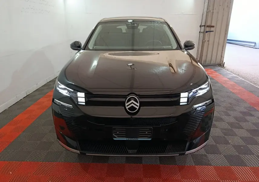 Citroën C5 Hybride noire vue de face, avec phares LED allumés et logo distinctif au centre de la calandre.