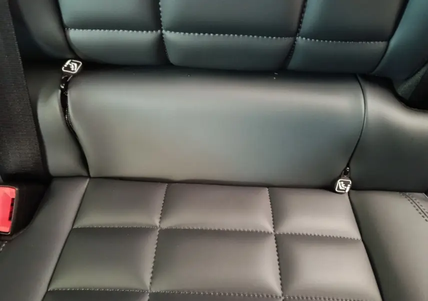 Gros plan sur la banquette arrière en cuir noir matelassé de la Citroën C5 hybride 2026, avec attaches ISOFIX visibles.
