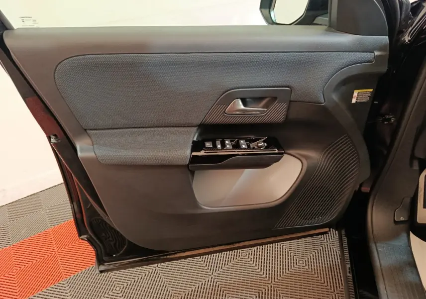 Vue intérieure de la porte avant gauche noire du Citroën C5 Hybride 2026 avec commandes électriques et finition texturée.