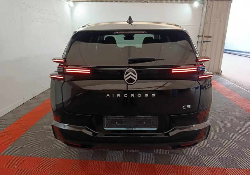 Vue arrière d'une Citroën C5 Aircross noire avec feux arrière LED allumés dans un garage.