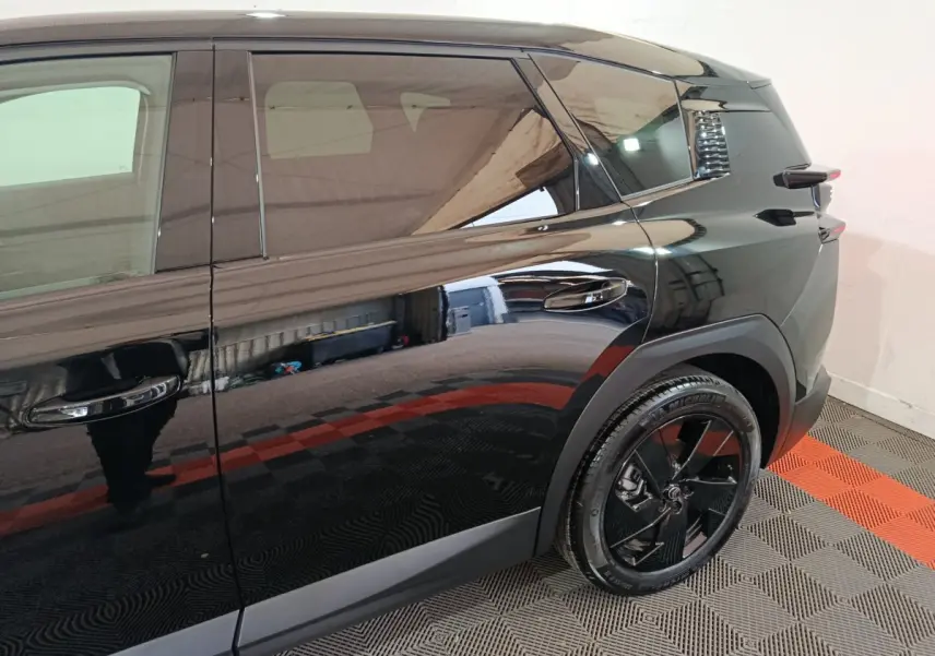 Vue latérale droite du Citroën C5 Hybride noir 2026, mettant en valeur la roue arrière et les lignes épurées du véhicule.
