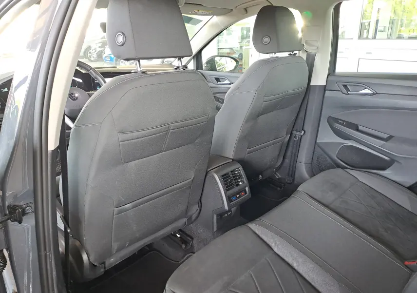 Écran central de la Volkswagen Golf VIII hybride montrant la caméra de recul avec guidage coloré en extérieur.