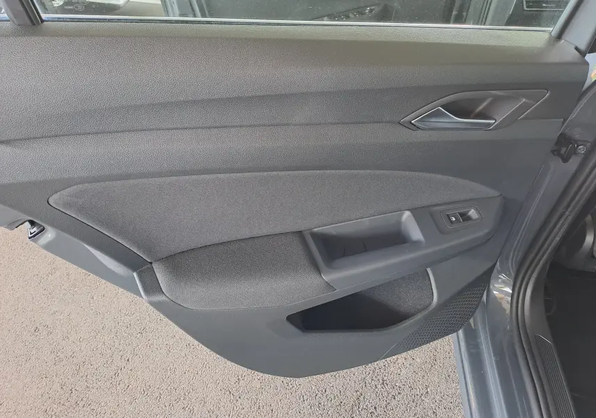 Vue intérieure arrière côté droit de la Volkswagen Golf VIII gris dauphin, montrant les sièges arrière en tissu gris et les appuie-têtes.