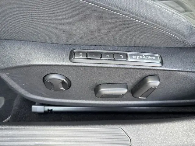 Intérieur côté passager de la Volkswagen Golf VIII gris dauphin, sièges tissu gris et tableau de bord moderne avec écran tactile.