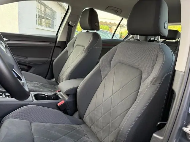 Vue intérieure côté conducteur montrant les sièges avant gris foncé en tissu et alcantara de la Volkswagen Golf VIII 1.4 e-Hybrid 2021.