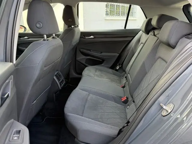 Profil côté gauche d'une Volkswagen Golf VIII 1.4 e-Hybrid gris dauphin, avec jantes alliage et portes fermées.