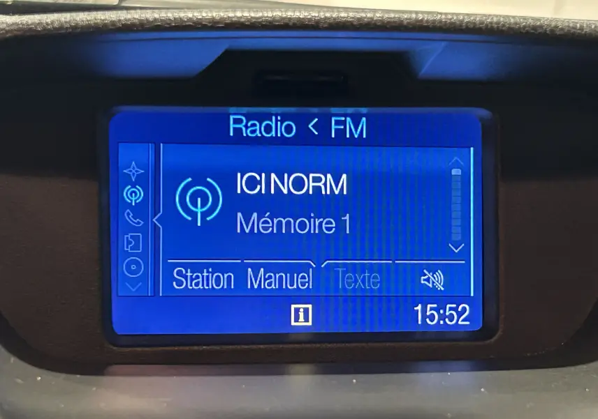 Écran central du tableau de bord du Ford EcoSport gris 2018 affichant la radio FM sur la station ICI NORM à 15h52