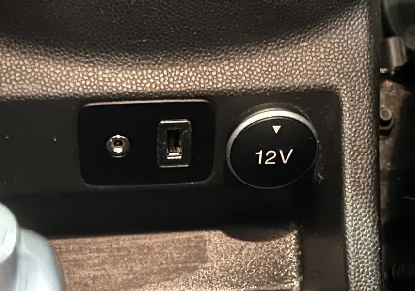 Prise 12V et port USB en gros plan sur la console centrale du Ford EcoSport gris 2018.