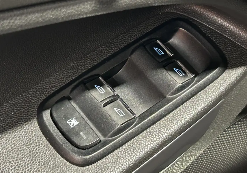 Gros plan sur les commandes de lève-vitres électriques noires côté conducteur du Ford EcoSport gris 2018.