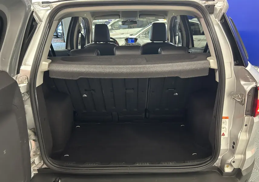 Vue arrière du coffre ouvert d'un Ford EcoSport gris 2018, montrant l'intérieur spacieux et les sièges arrière.