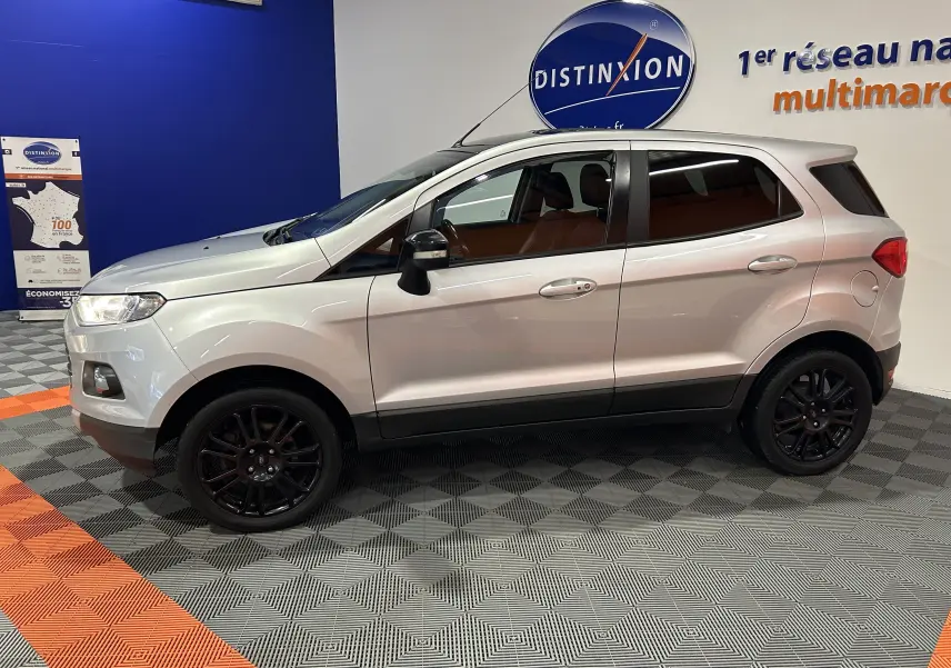 Vue de profil côté gauche d'un Ford EcoSport gris 2018 avec jantes noires et vitres teintées dans un showroom.