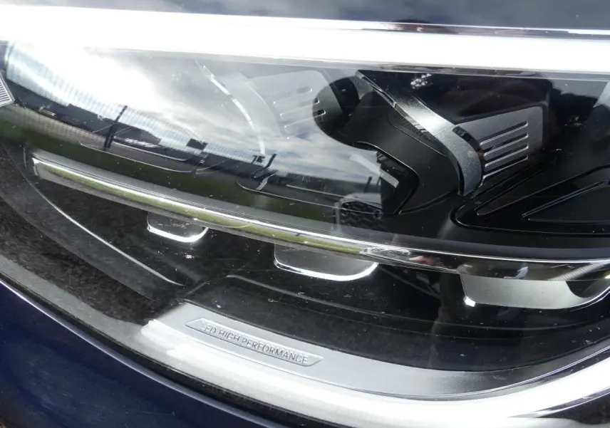 Gros plan sur le phare LED haute performance du Mercedes GLC Coupé 300 hybride bleu foncé, soulignant ses détails techniques.