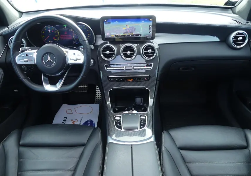 Intérieur Mercedes GLC Coupé 300 hybride 2022, tableau de bord noir avec écran central et volant multifonction cuir.