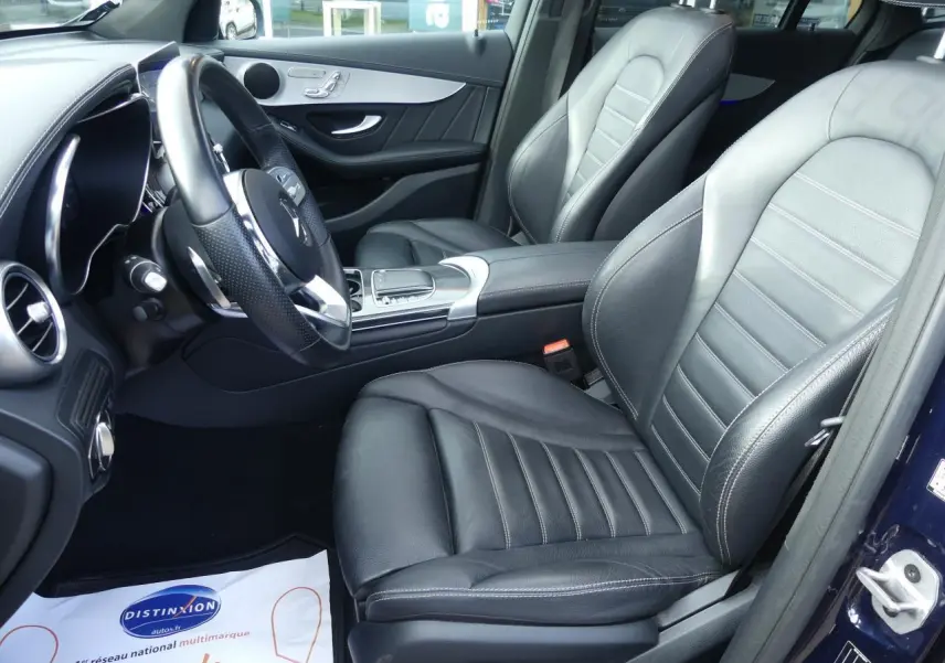 Intérieur avant droit d'une Mercedes GLC Coupé 300 hybride, sièges cuir noir et garnitures AMG carbone.