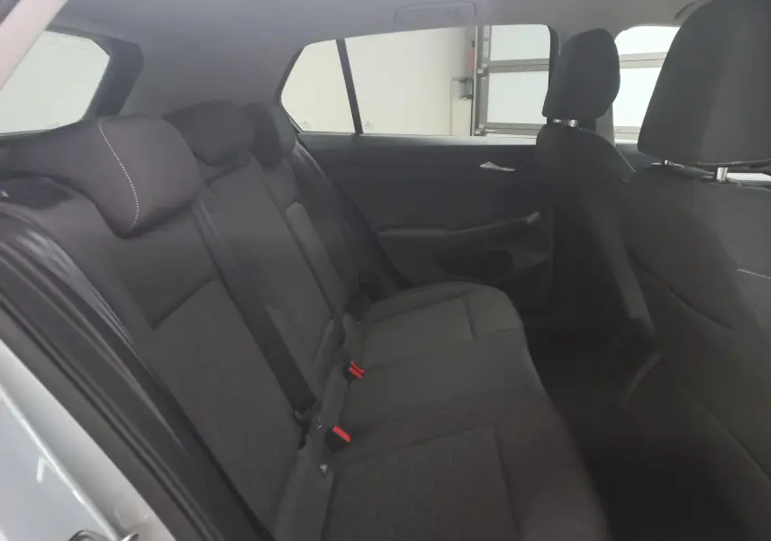 Vue intérieure côté gauche montrant la banquette arrière noire de la Volkswagen Golf 1.5 eHybrid 2025.