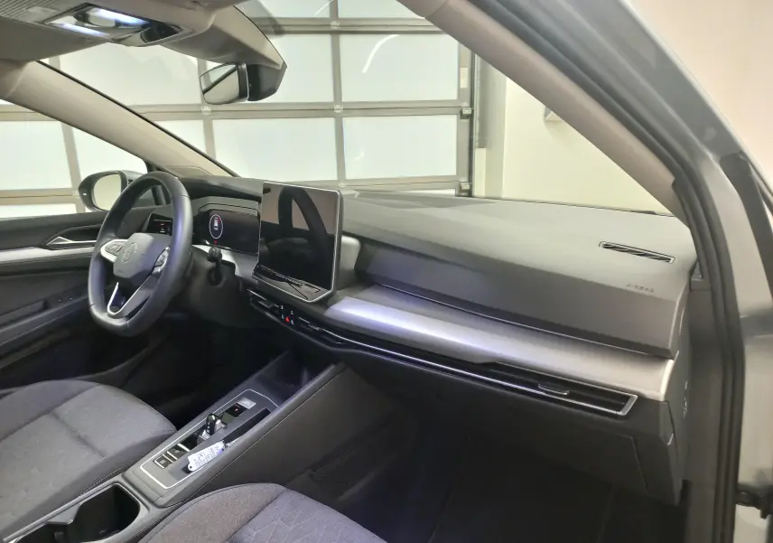 Vue intérieure côté conducteur de la Volkswagen Golf 1.5 eHybrid 2025 avec tableau de bord moderne et écran tactile.